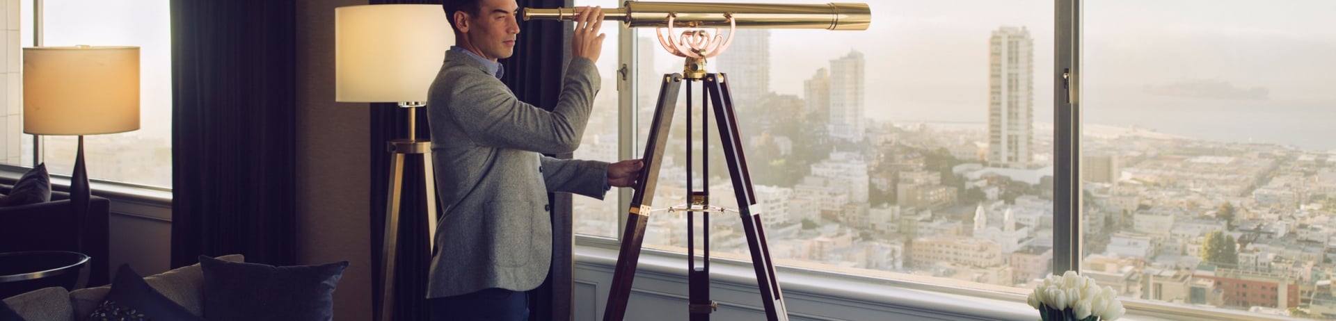 A man was looking out of the window with a telescope