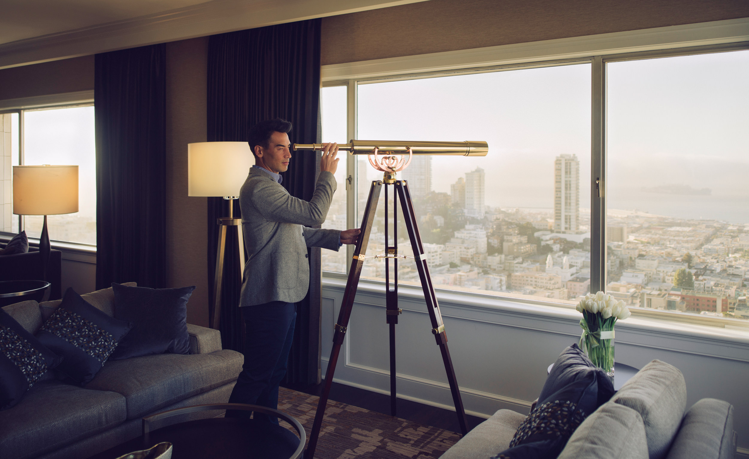 A man was looking out of the window with a telescope