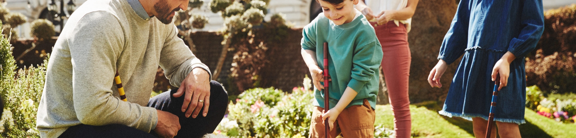 A family of four is playing on the lawn