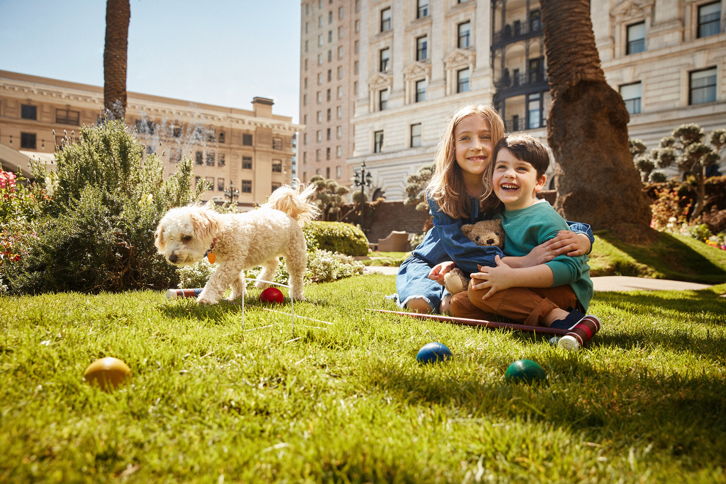 On the garden lawn were two smiling children and a white dog