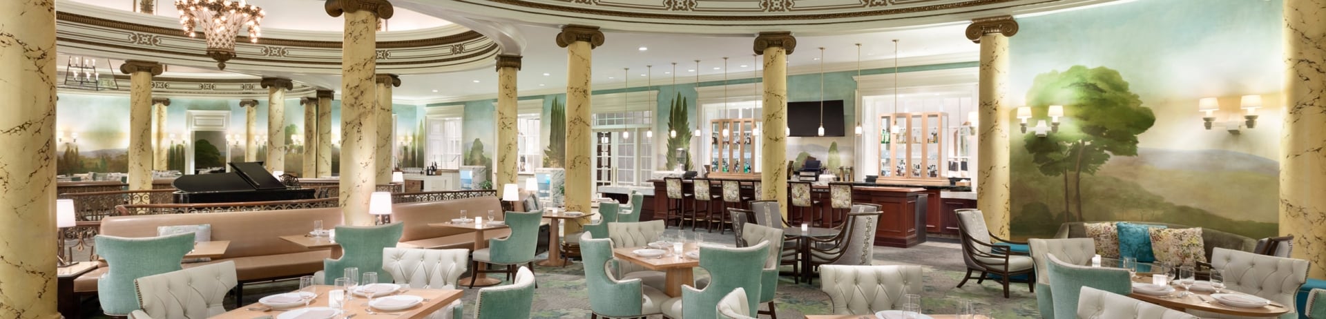 The dining room is filled with pale green chairs and square wood-grain tables