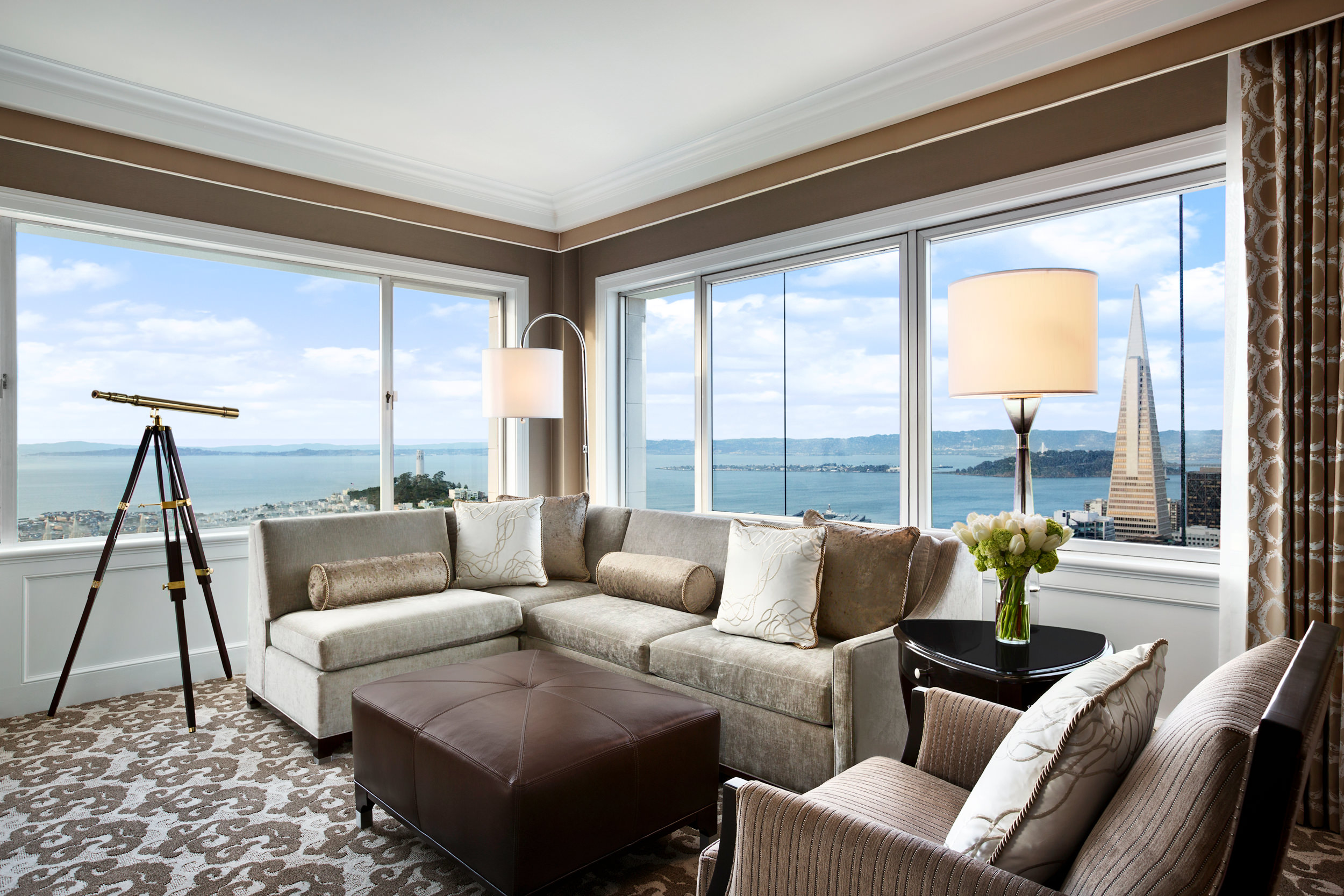 The living room has an L-shaped sofa, sofa stools and binoculars