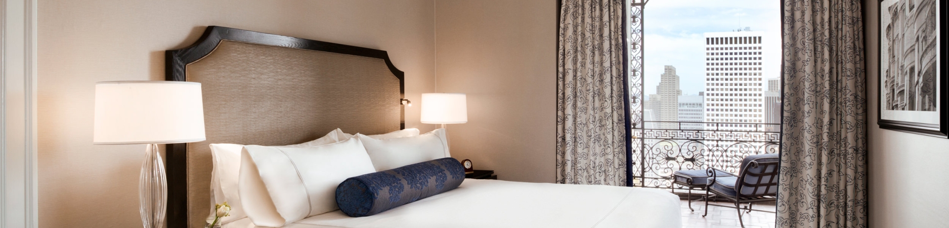 A bed is set up in a room with a view of the city
