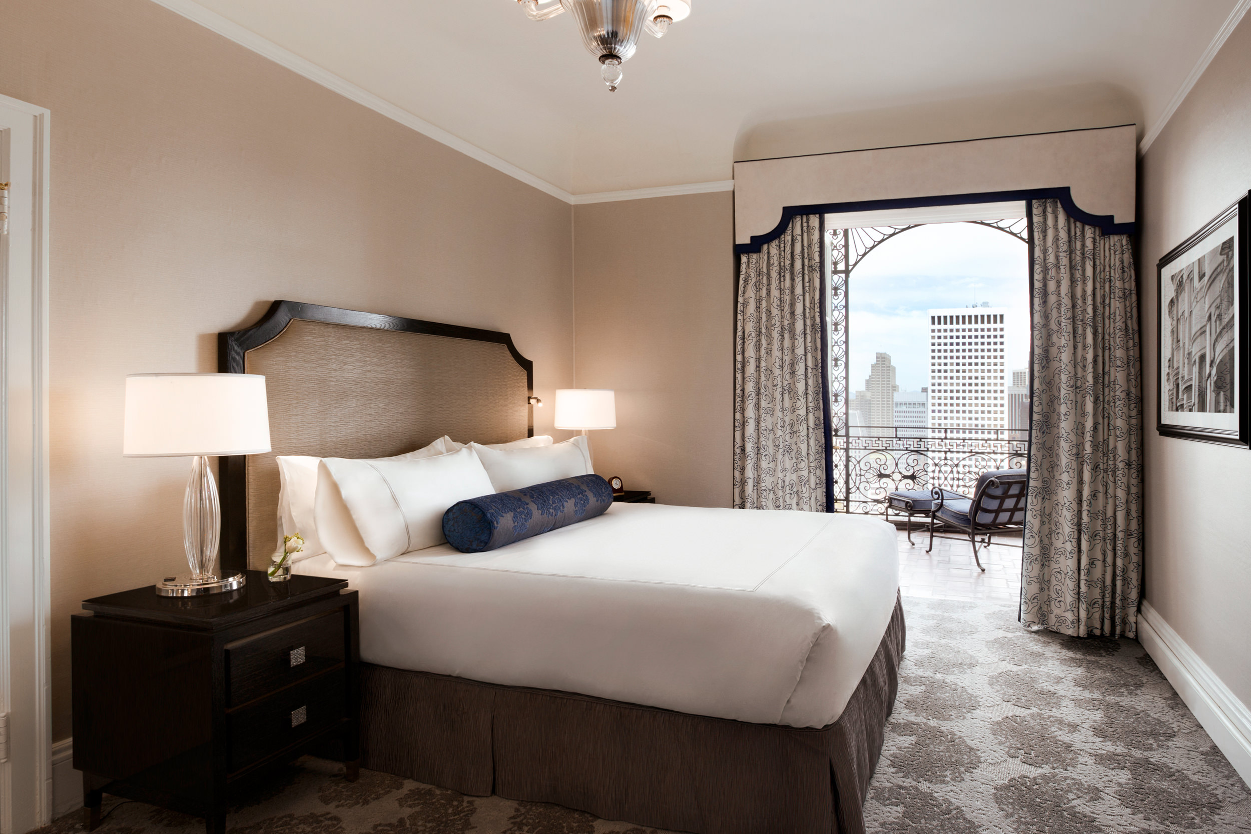 A bed is set up in a room with a view of the city