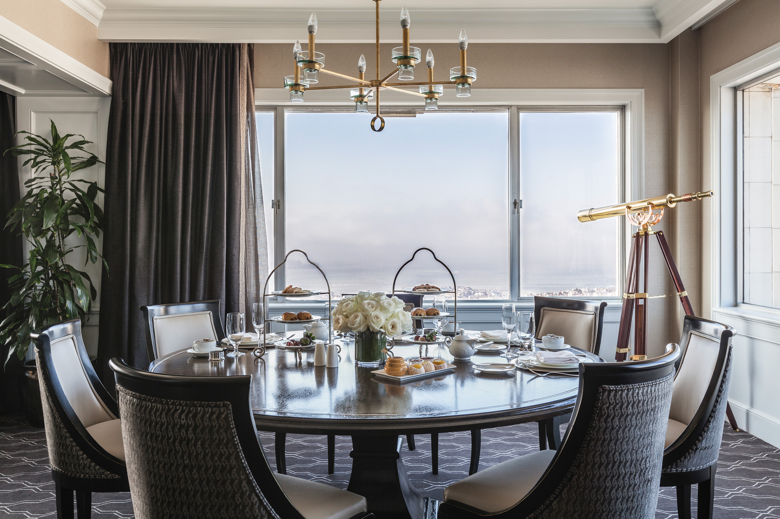 A round table was set with three layers of afternoon tea, coffee, tea and wine glasses