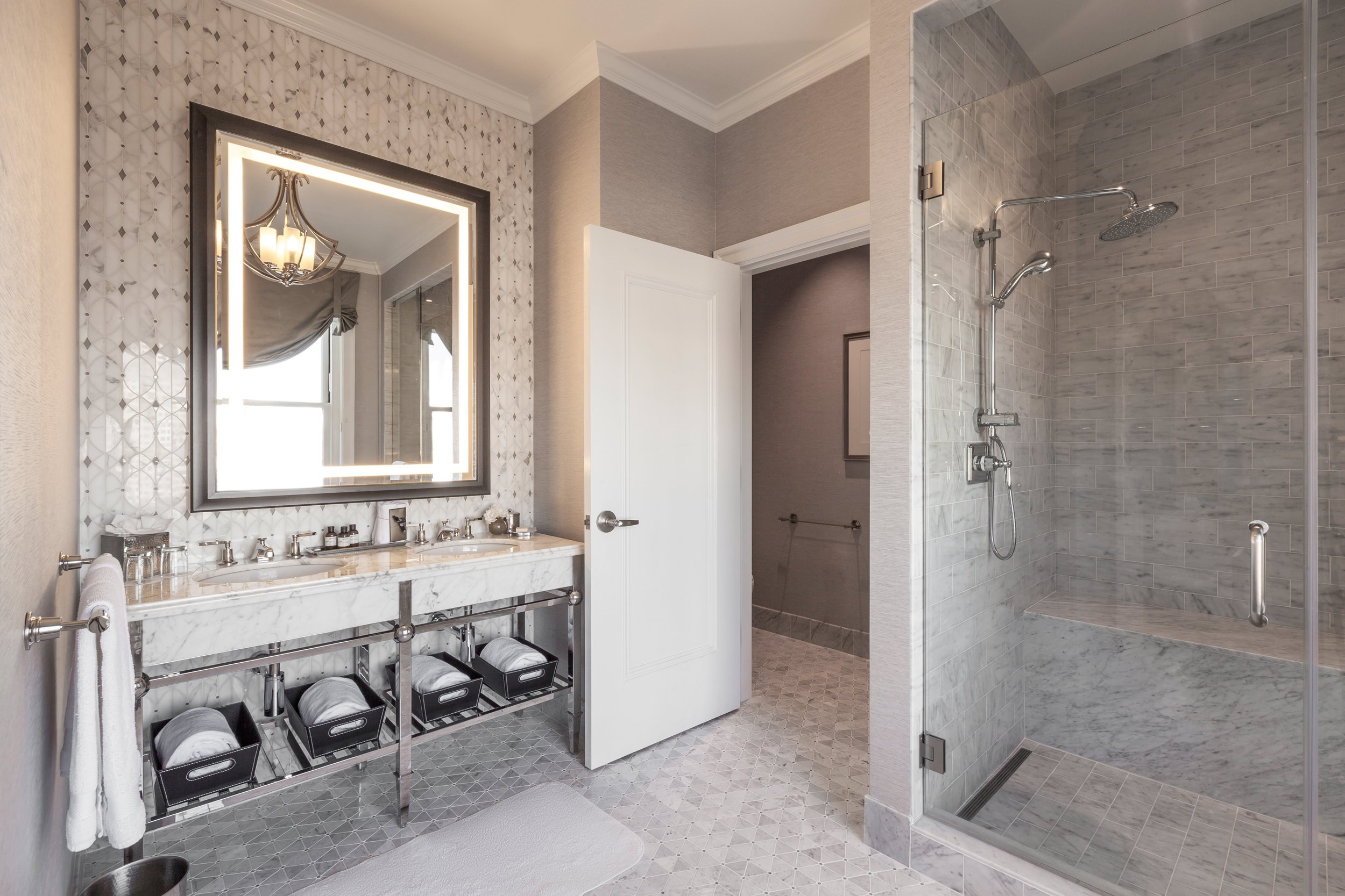 A bathroom with a double sink and a lighted mirror