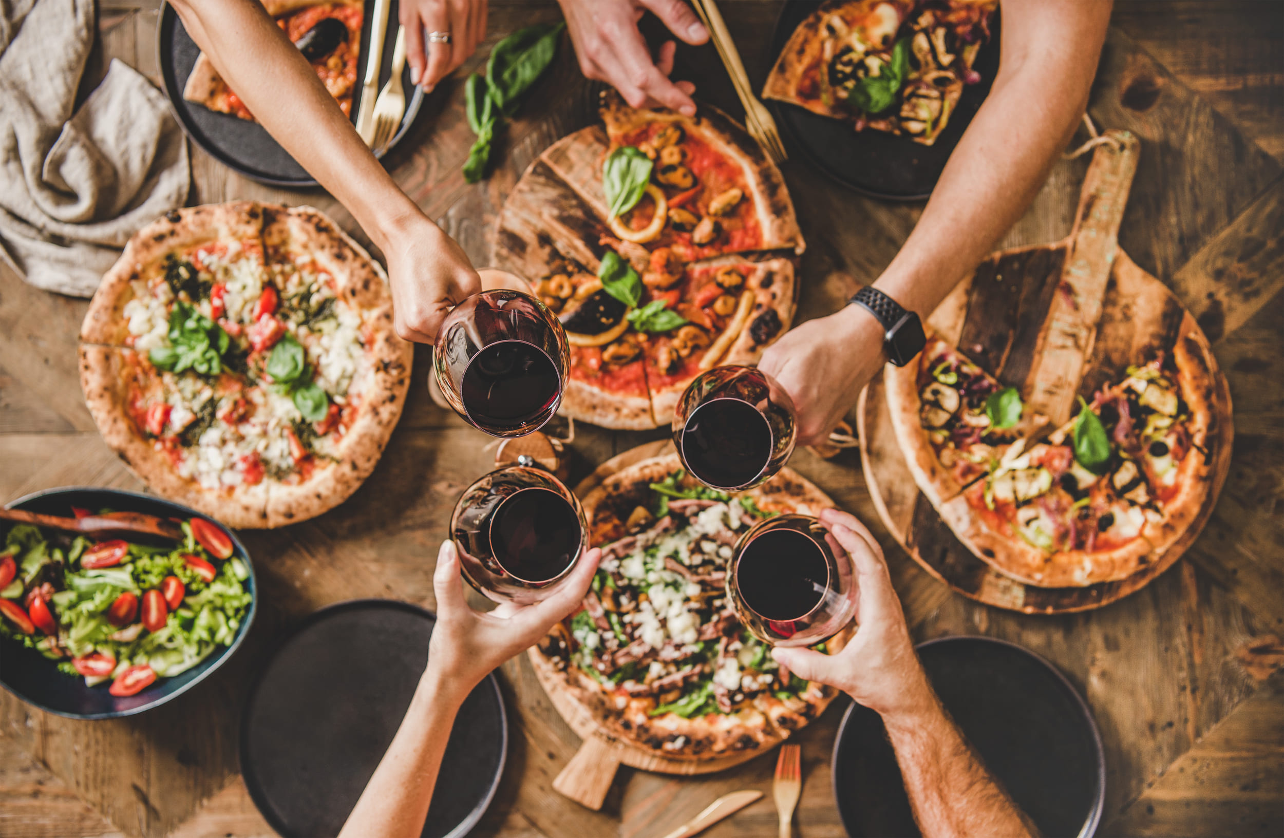 people enjoying pizza and wine